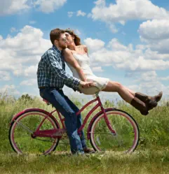 Glückliches Ehepaar fährt zusammen auf einem Fahrrad und schwört auf das Liebes Rezept