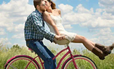 Ein glückliches Ehepaar fährt im Sommer zusammen auf einem Fahrrad